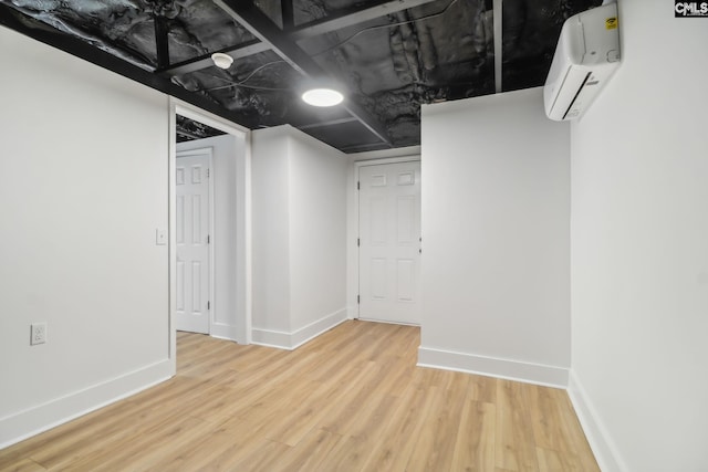 basement featuring hardwood / wood-style floors and an AC wall unit