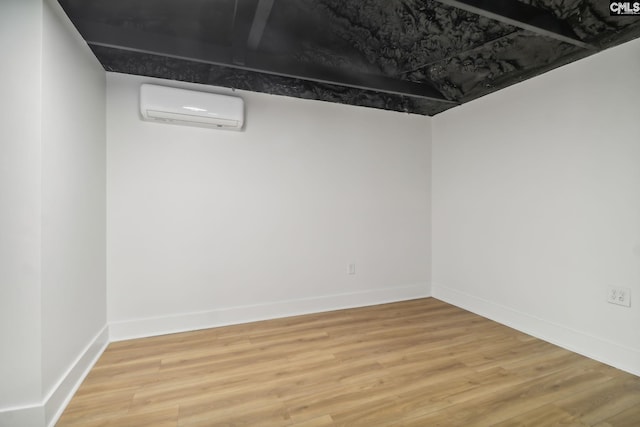 basement featuring hardwood / wood-style flooring and an AC wall unit