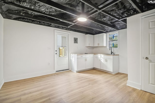 kitchen featuring white cabinetry, sink, and light hardwood / wood-style flooring