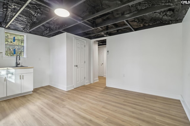 basement with light wood-type flooring and wet bar