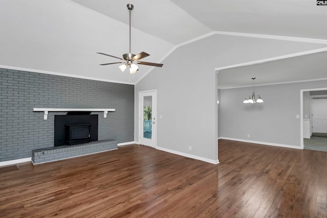 unfurnished living room featuring wood-type flooring, a wood stove, brick wall, vaulted ceiling, and ceiling fan