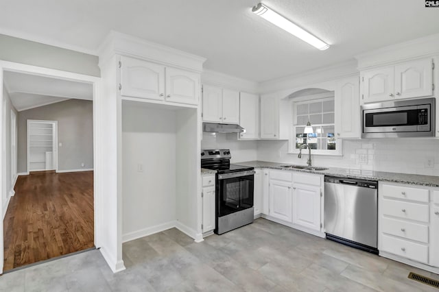 kitchen with light stone counters, appliances with stainless steel finishes, white cabinetry, light hardwood / wood-style floors, and sink