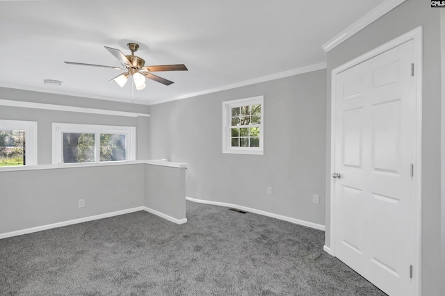 spare room featuring crown molding, ceiling fan, and dark colored carpet