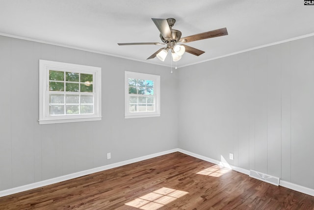 empty room featuring ceiling fan, wood-type flooring, and ornamental molding