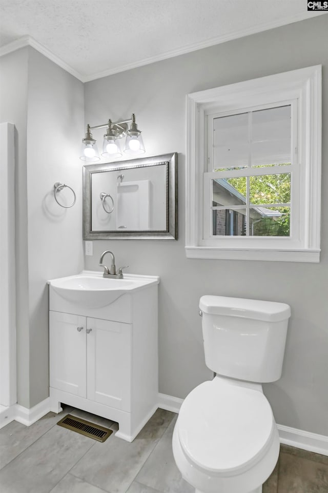 bathroom with vanity, crown molding, a textured ceiling, and toilet