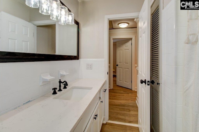 bathroom with vanity, ornamental molding, and hardwood / wood-style flooring