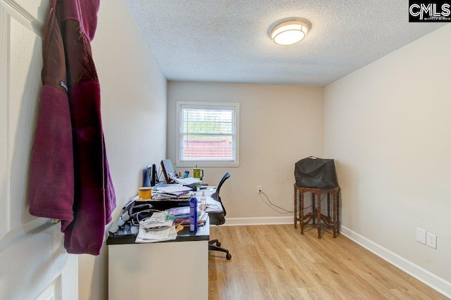 office space featuring a textured ceiling and light wood-type flooring