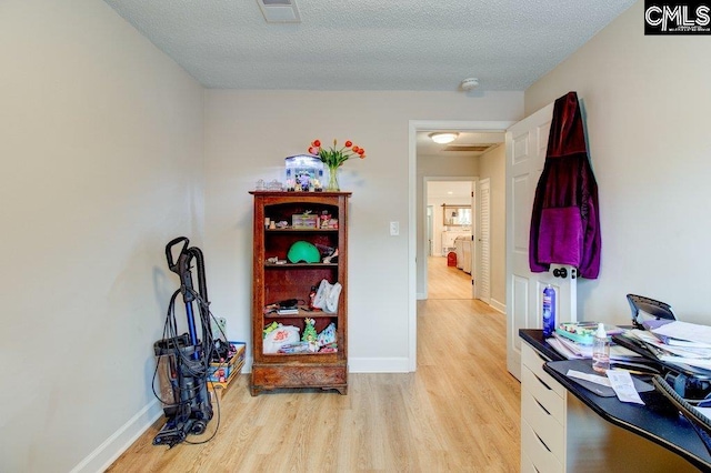 interior space with light hardwood / wood-style floors and a textured ceiling