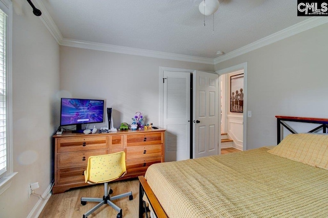 bedroom with light hardwood / wood-style floors, crown molding, multiple windows, and connected bathroom