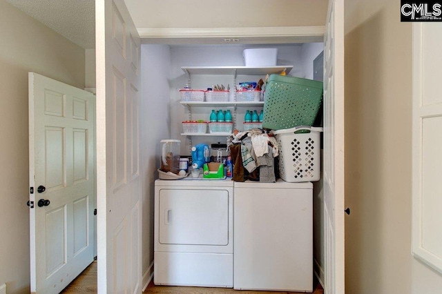 laundry room with a textured ceiling and washing machine and dryer