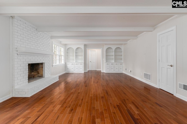 unfurnished living room with built in features, a brick fireplace, beamed ceiling, hardwood / wood-style flooring, and ornamental molding