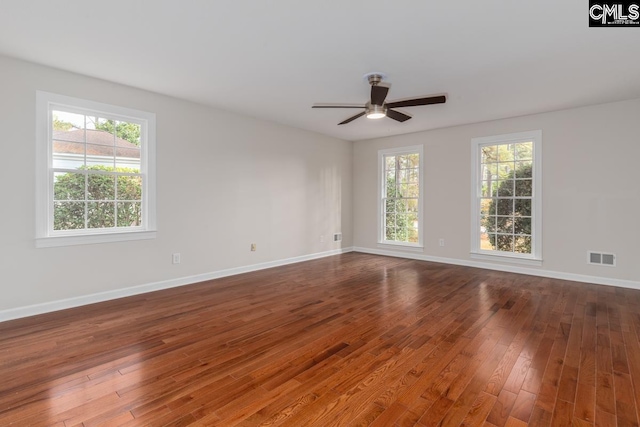 spare room with dark hardwood / wood-style floors, a healthy amount of sunlight, and ceiling fan