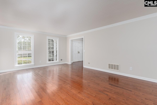 empty room featuring crown molding and hardwood / wood-style flooring