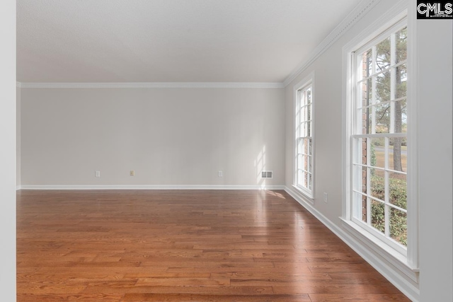 spare room featuring crown molding and hardwood / wood-style flooring