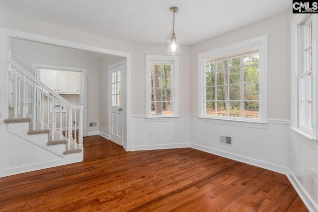 unfurnished dining area featuring dark wood-type flooring