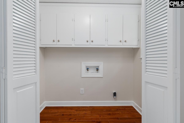 washroom featuring washer hookup, dark hardwood / wood-style flooring, and cabinets