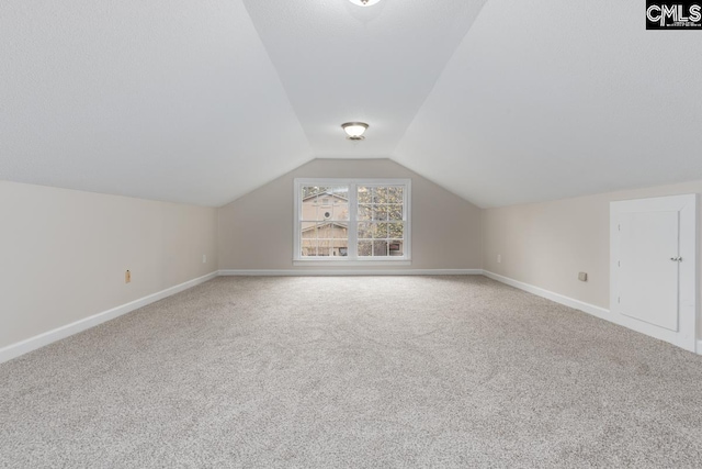 bonus room featuring vaulted ceiling and carpet floors