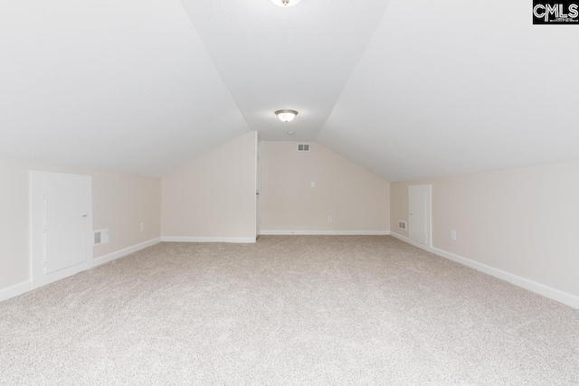 additional living space with carpet flooring and vaulted ceiling