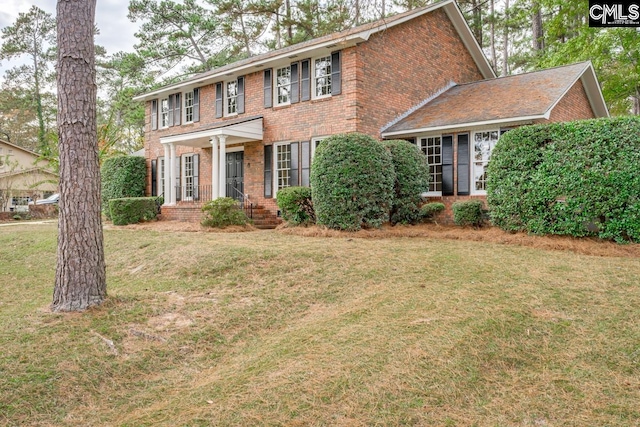 colonial home featuring a front yard