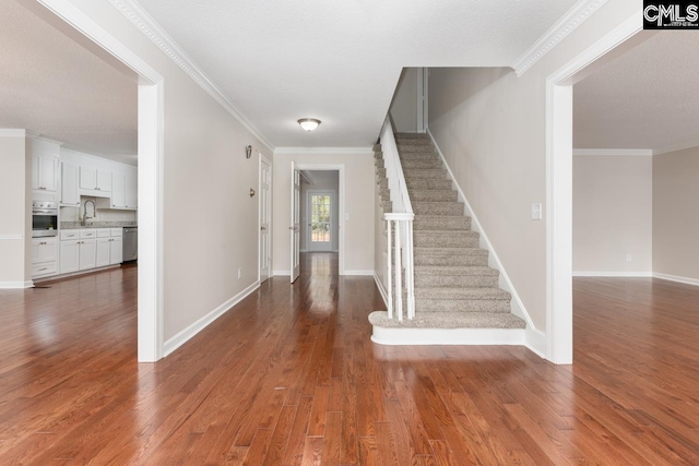 entryway with sink, crown molding, and dark hardwood / wood-style floors