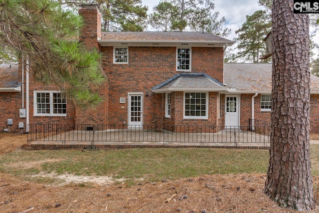 back of house with a patio area and a lawn