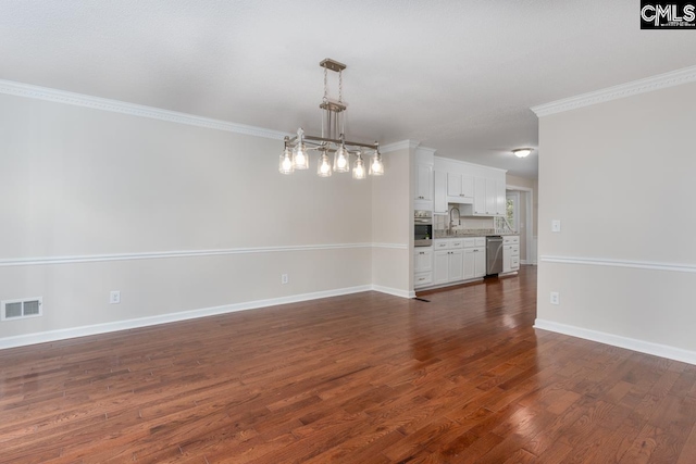 interior space with dark wood-type flooring, crown molding, and an inviting chandelier