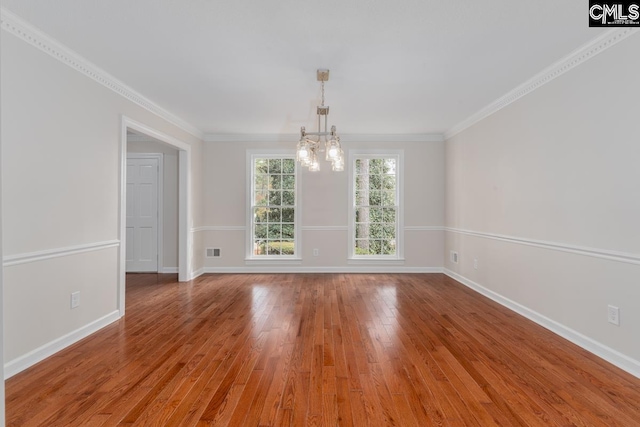 unfurnished room with ornamental molding, hardwood / wood-style floors, and a chandelier