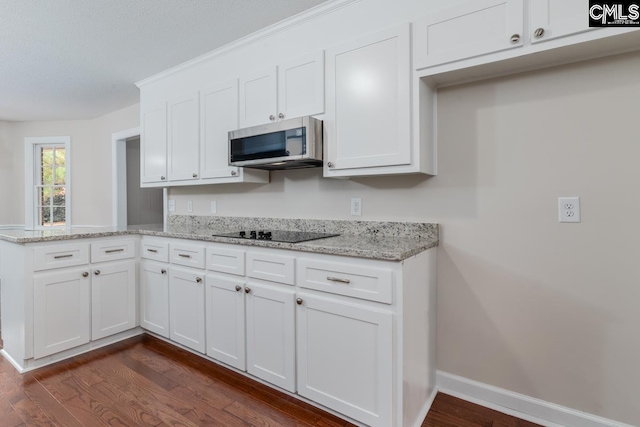 kitchen featuring black electric stovetop, light stone countertops, dark hardwood / wood-style flooring, and white cabinets