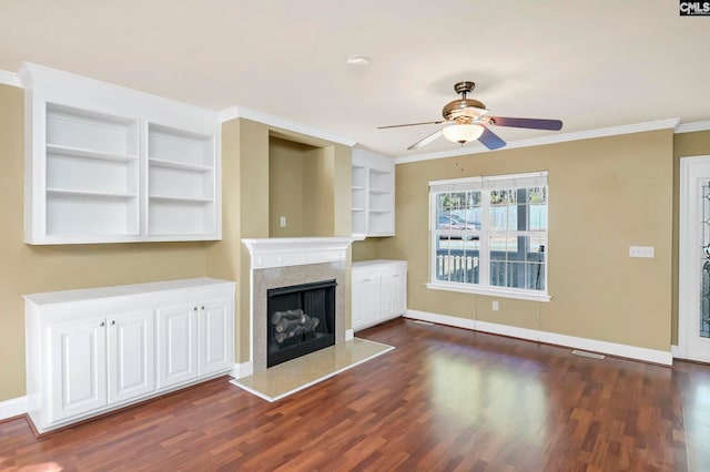 unfurnished living room with dark wood-type flooring, ceiling fan, and crown molding