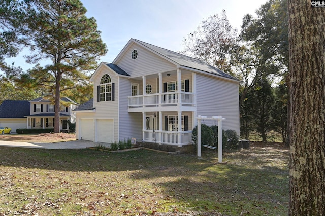 view of front of house with a front lawn, a garage, cooling unit, and a porch