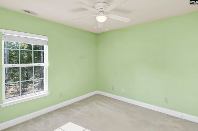 carpeted spare room featuring ceiling fan and a healthy amount of sunlight