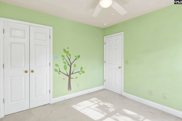 unfurnished bedroom featuring ceiling fan, a closet, and light colored carpet