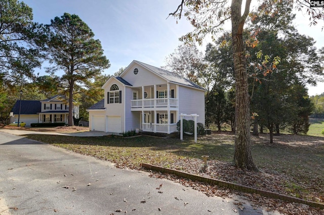 view of front of house featuring a garage, a porch, and a front lawn