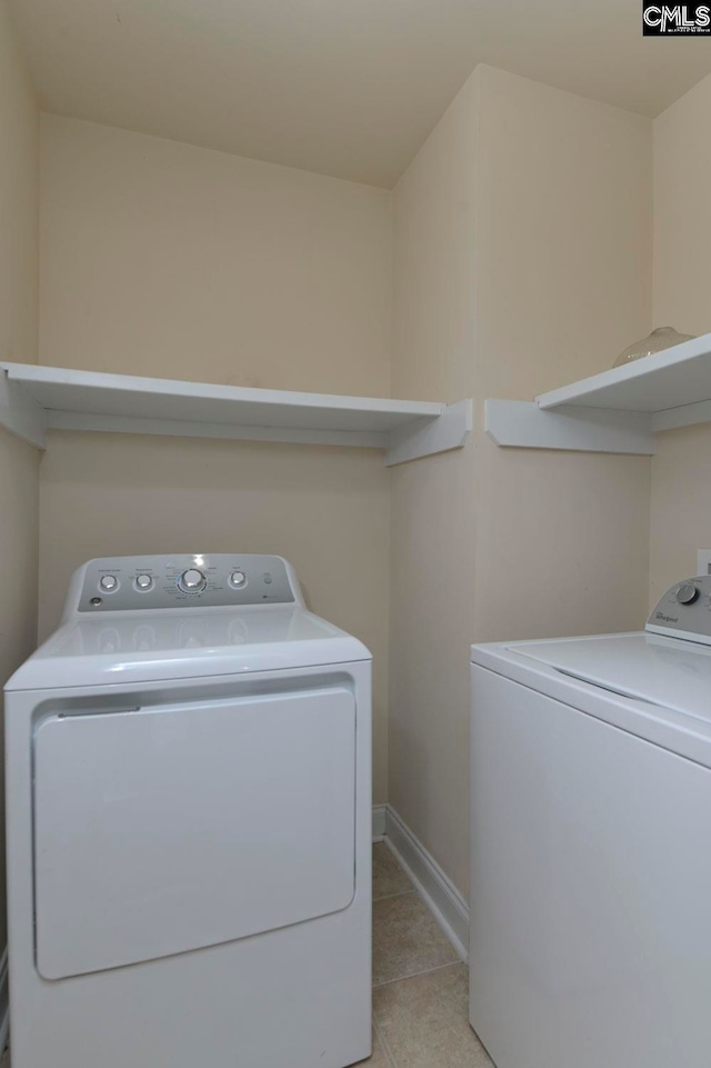 laundry room featuring separate washer and dryer and light tile patterned floors