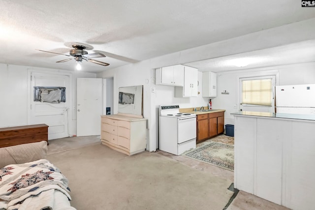 kitchen with a textured ceiling, sink, white cabinets, white appliances, and ceiling fan