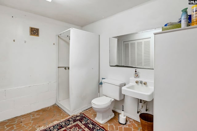 bathroom with a shower, toilet, and crown molding