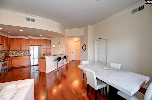 dining area with dark wood-type flooring and crown molding