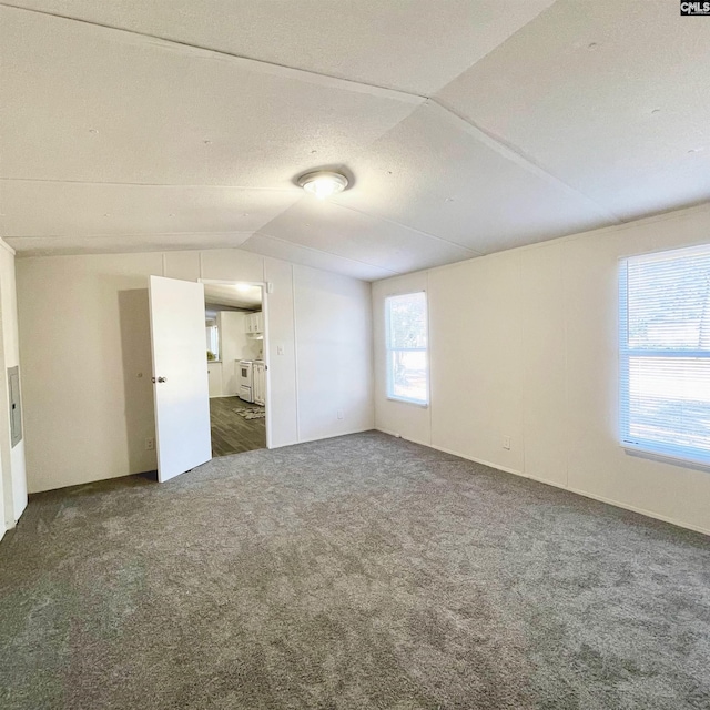 unfurnished bedroom featuring dark colored carpet, a textured ceiling, and vaulted ceiling