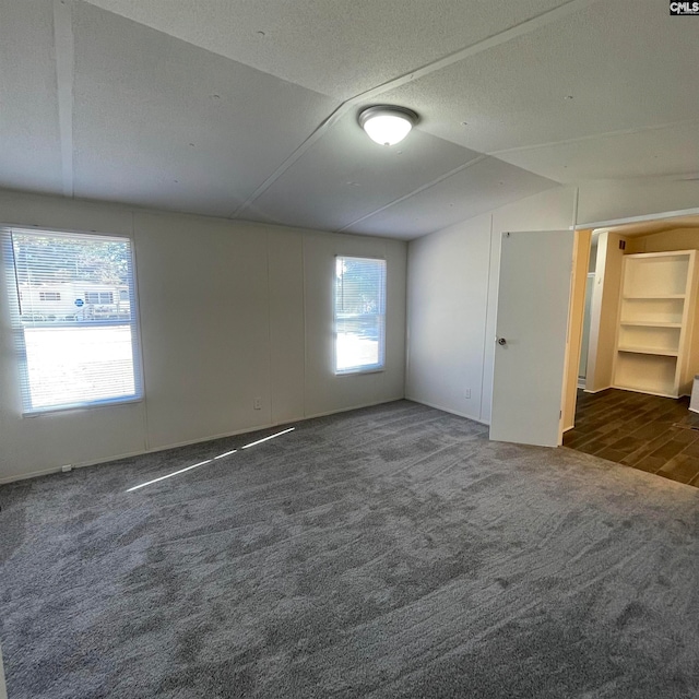 carpeted spare room with lofted ceiling