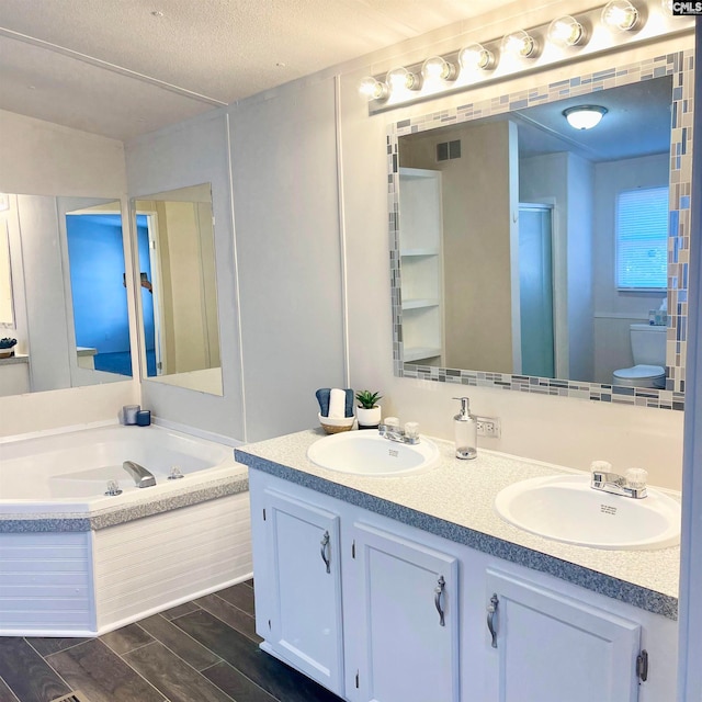 bathroom featuring shower with separate bathtub, wood-type flooring, a textured ceiling, and vanity