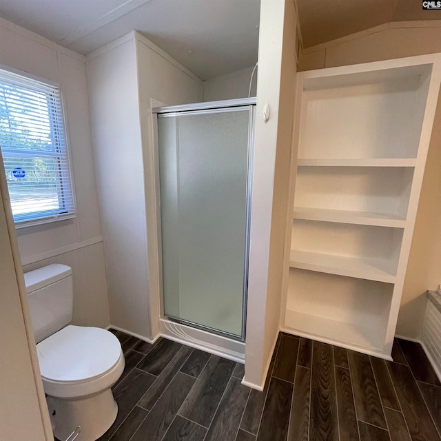 bathroom with toilet, an enclosed shower, and hardwood / wood-style floors