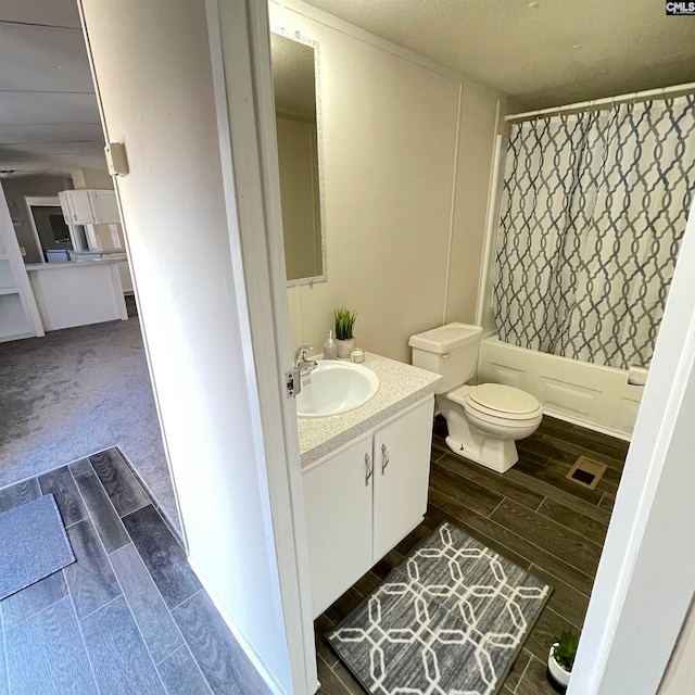 full bathroom with shower / tub combo with curtain, vanity, toilet, and a textured ceiling