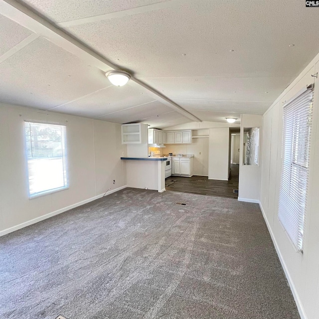 unfurnished living room featuring dark carpet