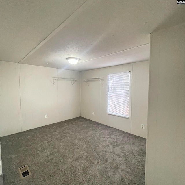 carpeted empty room with a textured ceiling