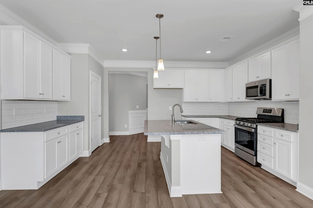 kitchen featuring appliances with stainless steel finishes, sink, light hardwood / wood-style floors, and a kitchen island with sink