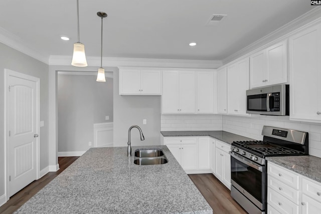 kitchen with stainless steel appliances, light stone countertops, white cabinetry, and sink