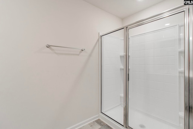 bathroom featuring a shower with door