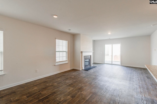 unfurnished living room with a healthy amount of sunlight and dark hardwood / wood-style floors