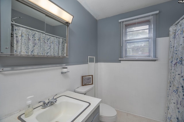 bathroom featuring tile walls, vanity, toilet, and a shower with shower curtain