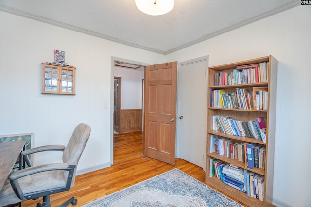 office area featuring wood walls, a textured ceiling, light wood-type flooring, and crown molding